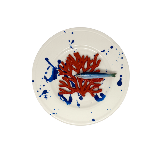 Koraal piccolo met sardientje op wit bord met blauwe verfspetters, 21 cm rond.
