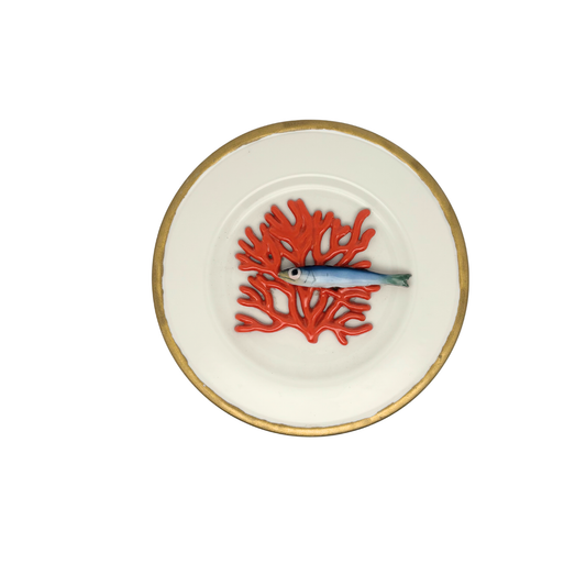 Koraal piccolo met sardientje op wit bord met goudkleurige rand, 21 cm.