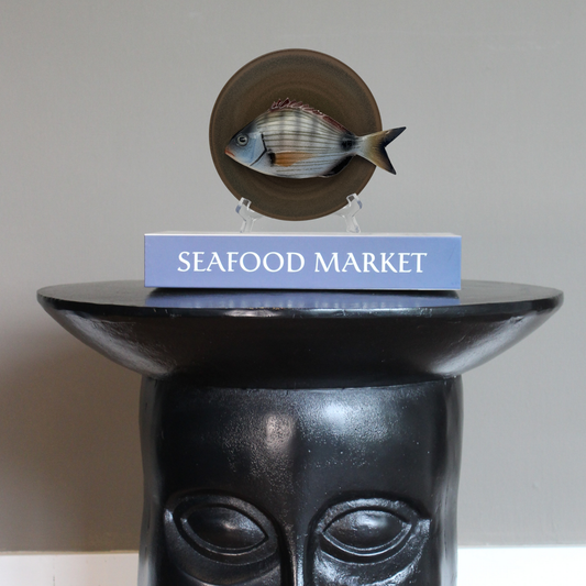 Sarago medio op een taupe kleur bordje, 16cm rond