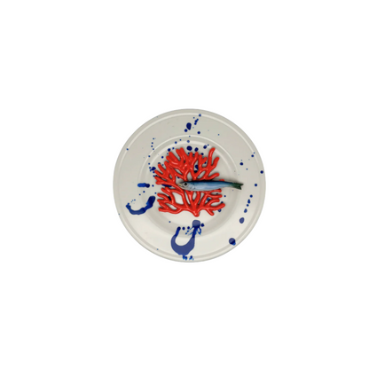 Koraal piccolo met sardientje op wit bord met blauwe verfspetters, 21 cm rond.